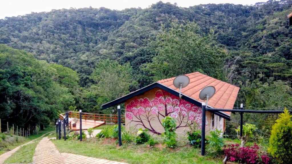 un bâtiment avec une peinture sur le côté dans l'établissement Sonho na Serra Chalé 1, à Gonçalves