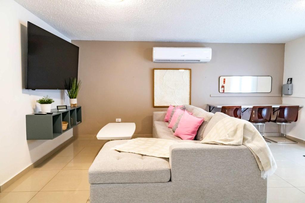 Una sala de estar con un sofá y un televisor de pantalla plana. en Aquaville Dorado Moderna Villa 4, en Dorado