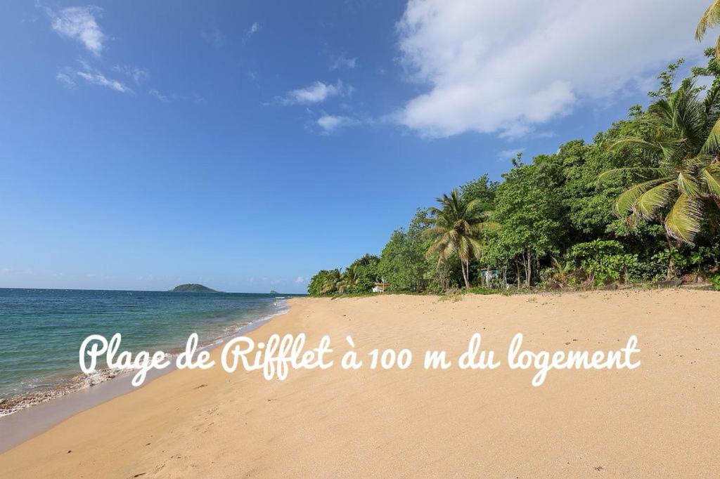 a beach with a sign that reads place be purified a no voc oil department at Tibo bas de villa NEUF accès mer in Deshaies