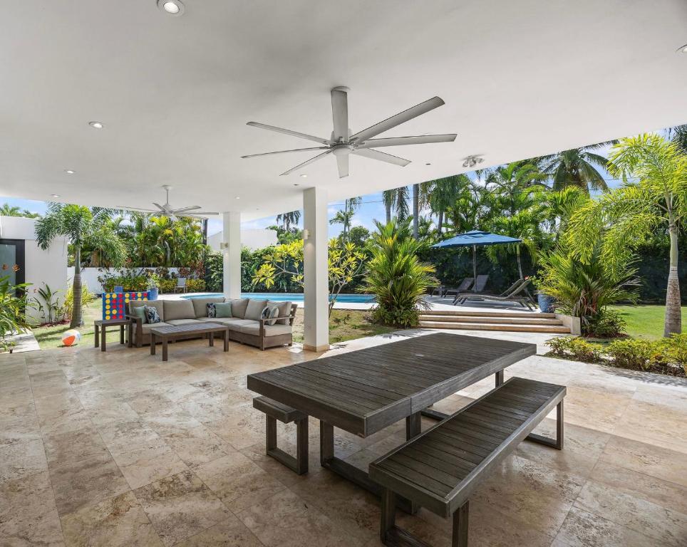 a living room with a table and a ceiling fan at Intimate Paradise-Pool, Terrace & Private Bedrooms in San Juan