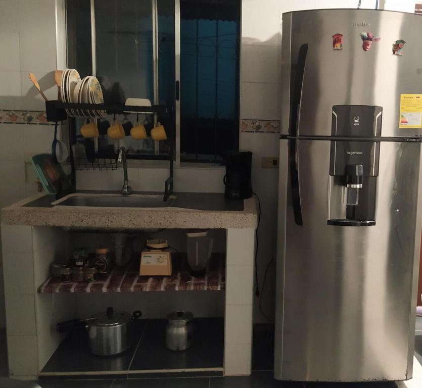 a kitchen with a stainless steel refrigerator and a sink at Casa azul en Piedecuesta in Piedecuesta