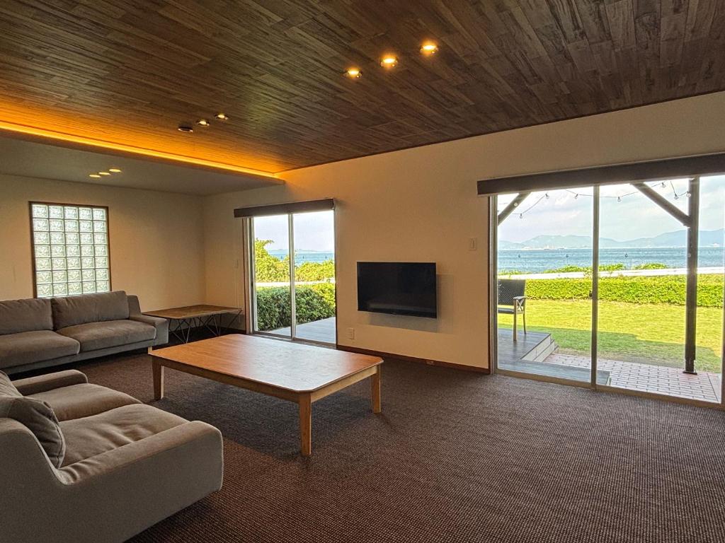 ein Wohnzimmer mit einer Couch und einem Couchtisch in der Unterkunft Seaside Villa KAMANO in Aji