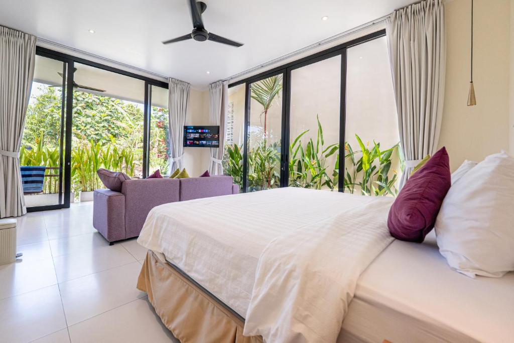 a bedroom with a large bed and a couch at Villa Dua Sungai in Sempidi