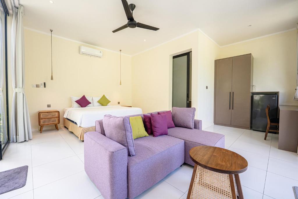 a living room with a couch and a bed at Villa Dua Sungai in Sempidi