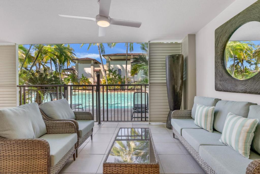 un soggiorno con divani e un balcone con piscina di Lagoon Sanctuary - Resort Living by Four Mile Beach a Craiglie