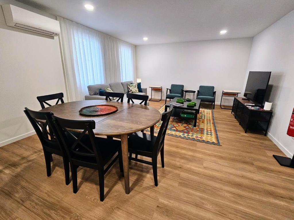 a room with a table and chairs and a couch at Apartamento Sonho Jardim in Ponta Delgada