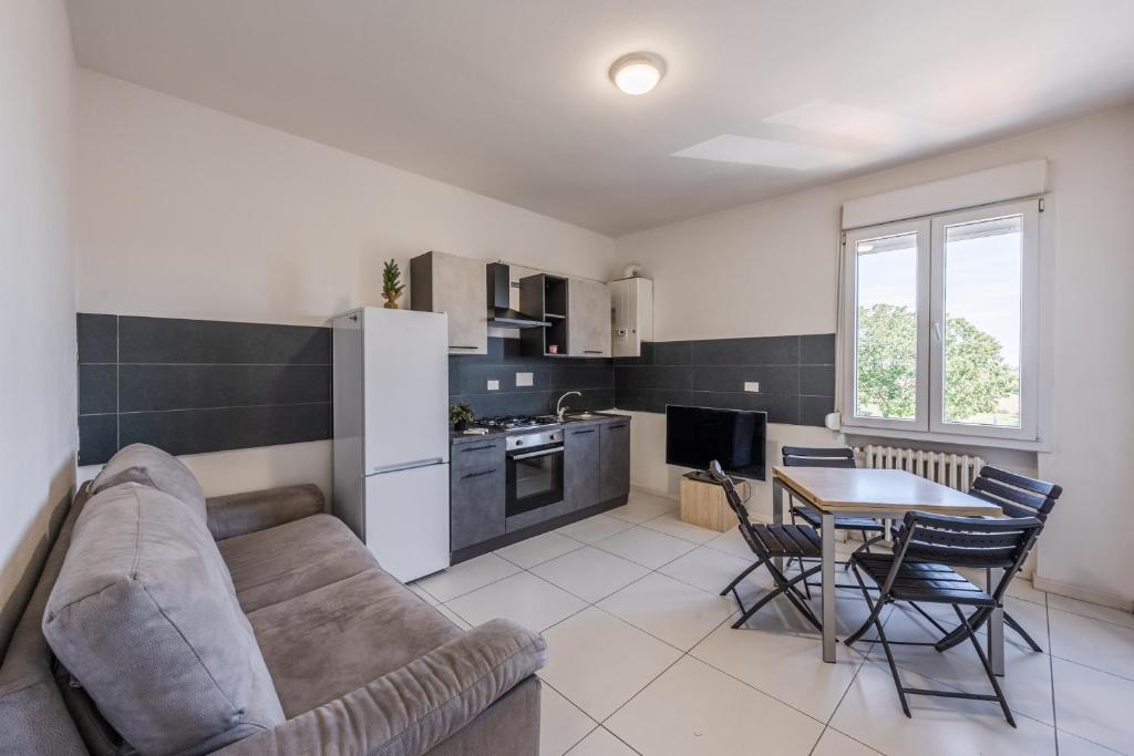 a kitchen and living room with a couch and a table at Rubiera Residence - H24 in Zimella