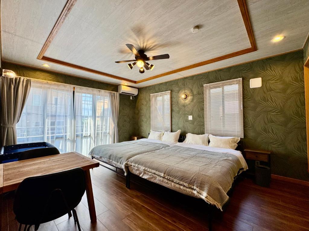 een slaapkamer met een bed en een plafondventilator bij ヴィラ マイラニハウス沖縄 in Hamakawa