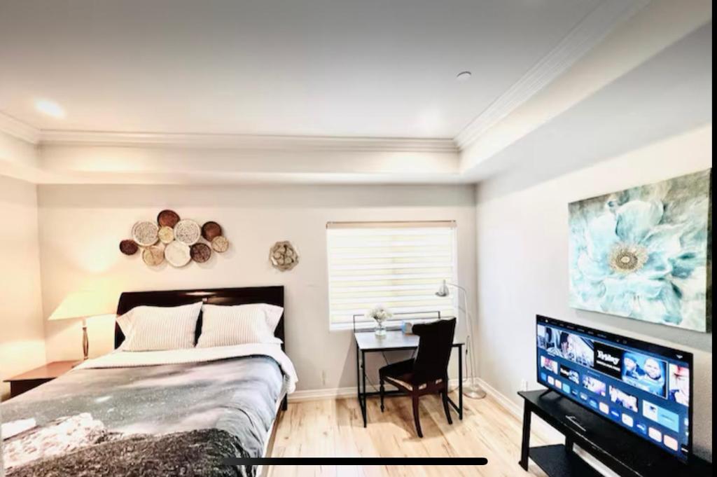 a bedroom with a bed and a desk and a tv at Rowland Heights in Rowland Heights