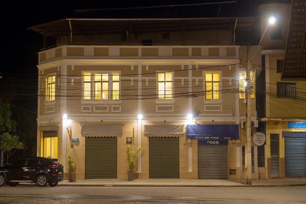 a building with doors and windows at night at Estação Pousada e Hostel in Cataguases