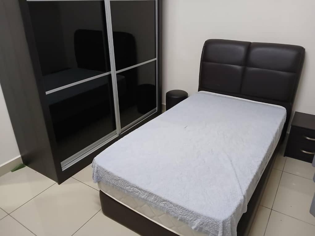 a small bed in a room with a cabinet at Adeline's Homestay Balik Pulau in Balik Pulau