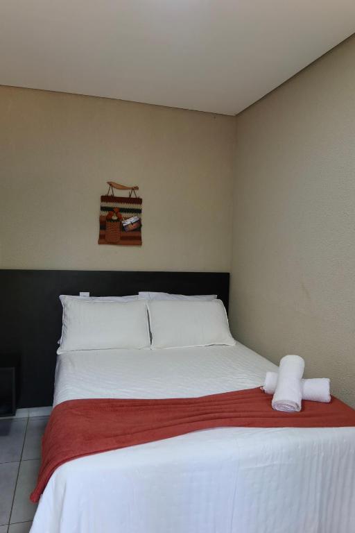 a bedroom with a large bed with two towels on it at Morada do Lago in Palmas