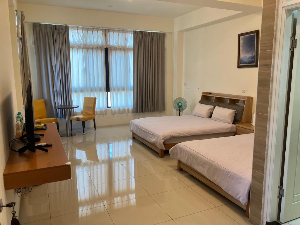 鹿港鎮にあるShan Hang Juのベッド2台とテレビがあるホテルの部屋