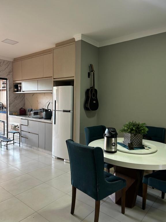 een keuken en eetkamer met een tafel en stoelen bij Casa aconchegante em local Estratégico in Foz do Iguaçu