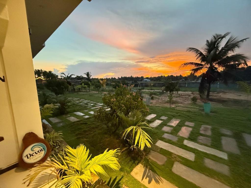Blick auf eine Palme und einen Sonnenuntergang in der Unterkunft Asai surf inn Arugambay in Arugam Bay