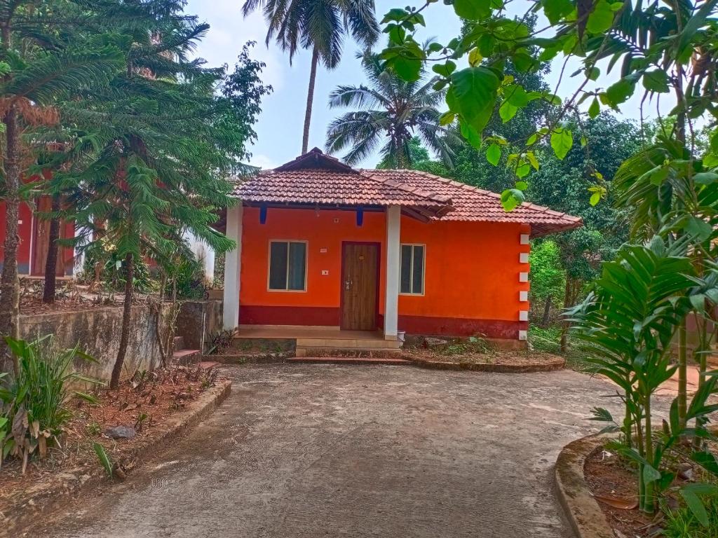 ein kleines Haus mit einer Orange in der Unterkunft Kamath regency and cottages in Dharmastala