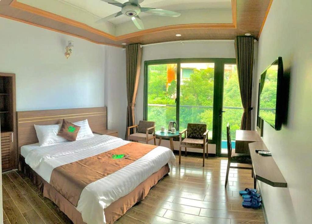 a bedroom with a bed and a table and a window at Khách sạn Rosalia in Tam Ðảo