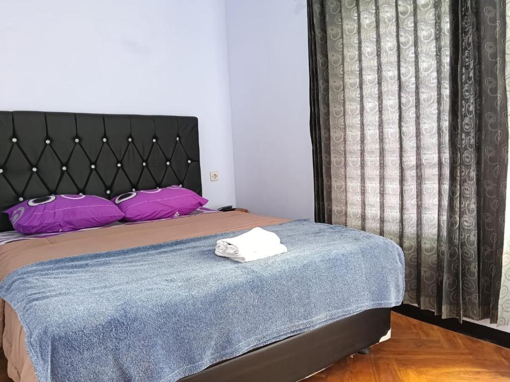 a bedroom with a bed with purple pillows at Den Bagus Bromo in Ngadisari