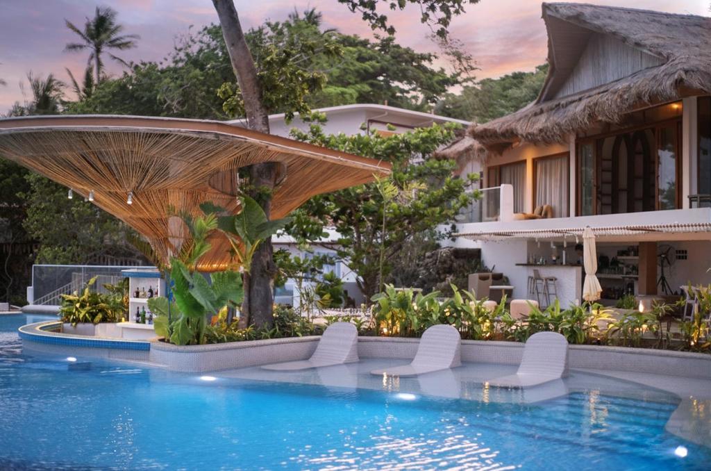 Una piscina en un resort con sillas y sombrilla. en Solea Reef Resort Anda, en Anda