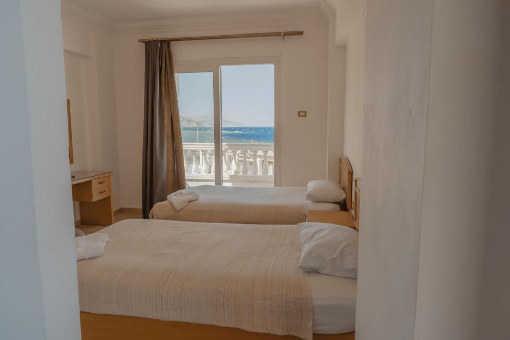 ダハブにあるDahab Hotelのベッドが2つと窓があるホテルの部屋