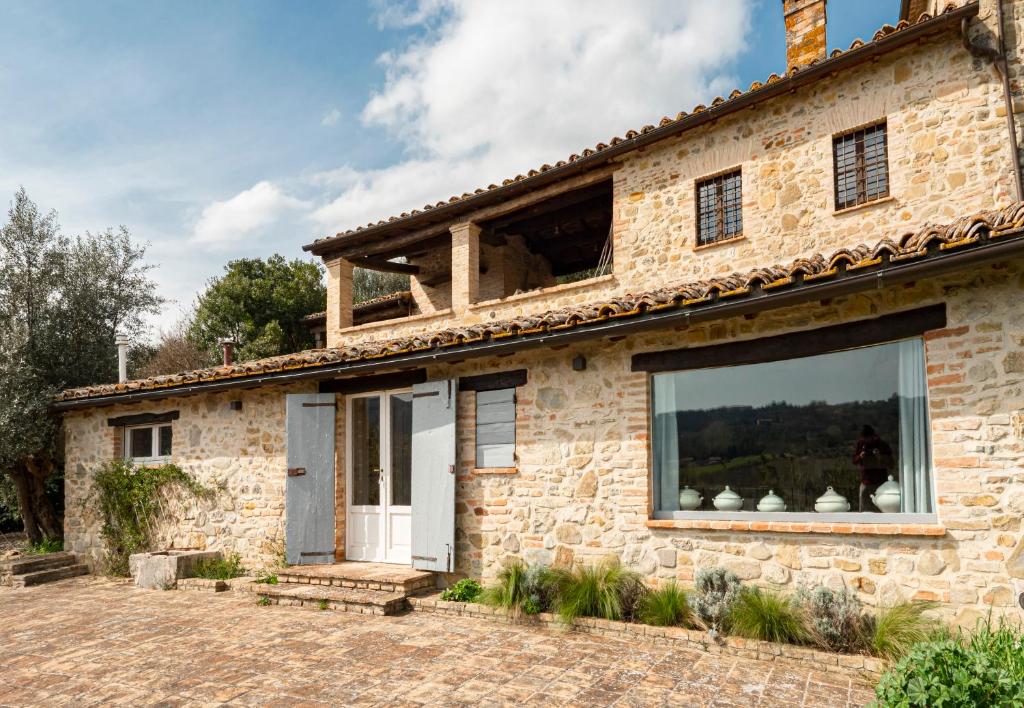 a stone house with a large window on the side of it at Casale Greppobello in Perugia