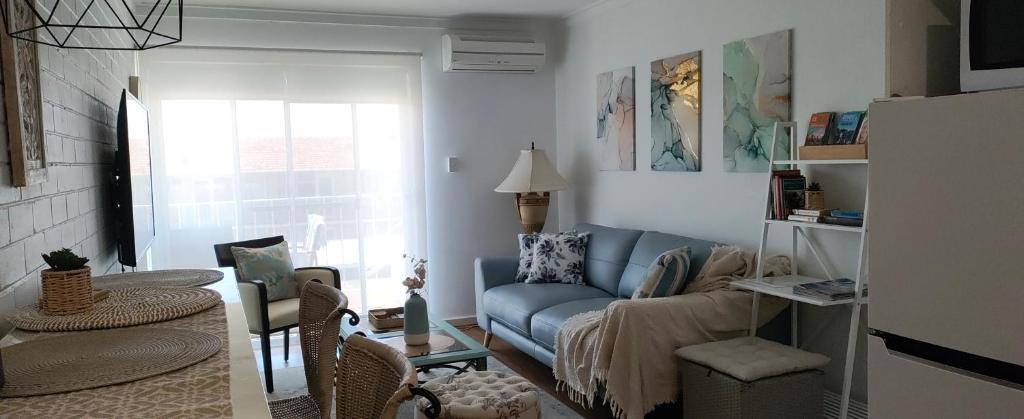a living room with a blue couch and a chair at Delightful Unit Near CBD & Beach, Free Parking in Perth