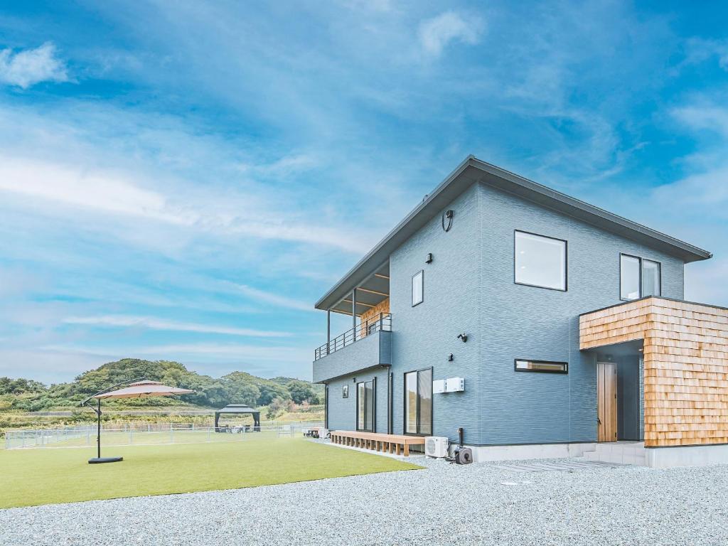 een blauw huis met een tennisbaan op de achtergrond bij Awaji Nature Retreat in Awaji