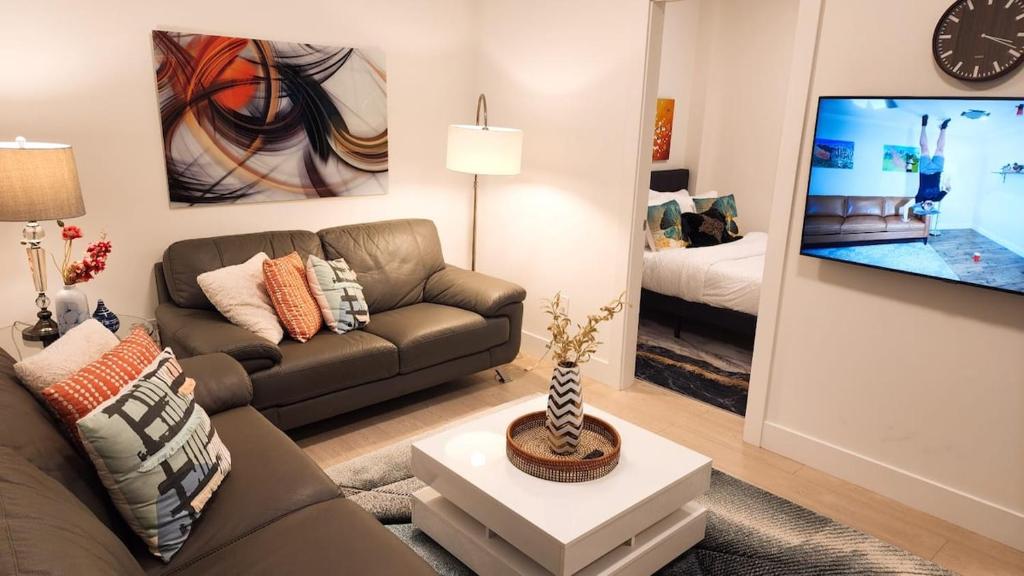 a living room with a couch and a tv at New Langford Suite near Lake & Mall, Free Parking in Goldstream Station