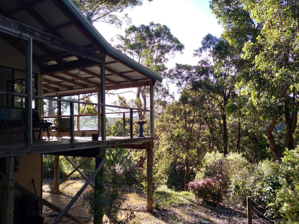 a wooden house with a deck in the woods at The Perch in Nornalup