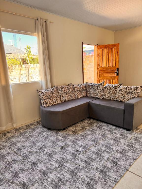 un sofá gris en una sala de estar con ventana en Refujo Ideal em Família, en Prado