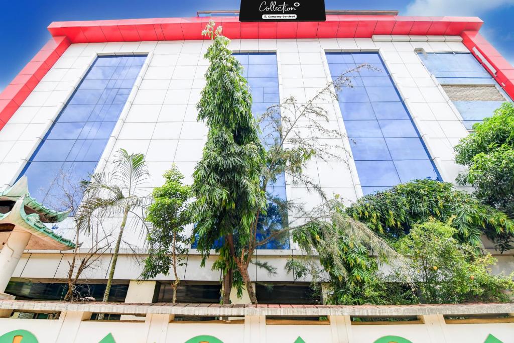 un edificio blanco alto con un árbol delante de él en Super Collection O Tamando Jagannath Temple Formerly Hotel Blue Royal, en Jānla