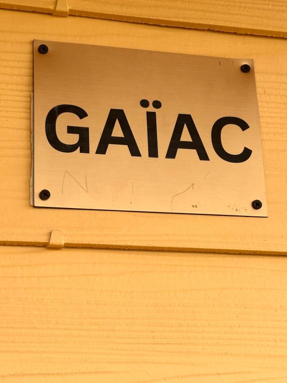 ein Schild mit der Aufschrift „Gaac“ an einer Holzwand in der Unterkunft Studio Karenga in La Tontouta