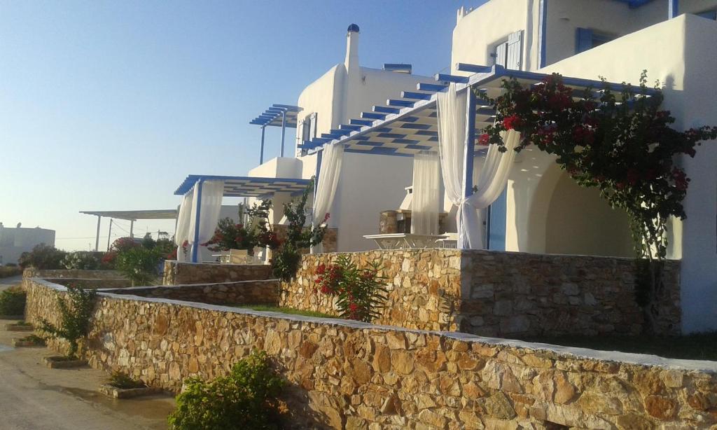 a house with a stone wall and flowers on it at S & K Maisonnettes in Pounda