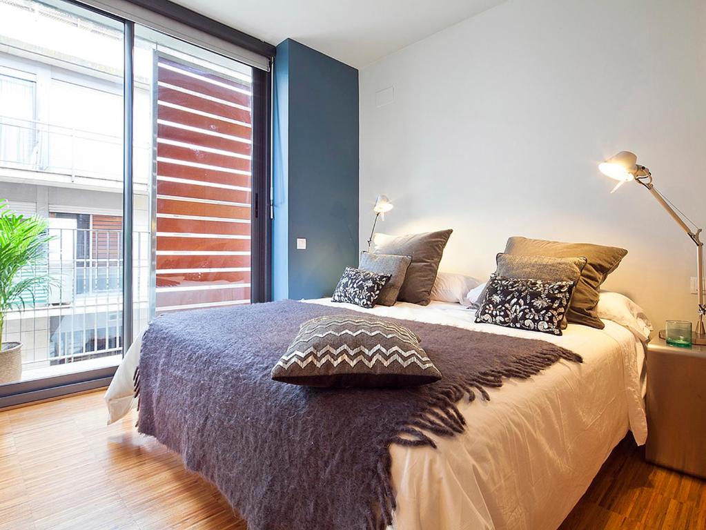 a bedroom with a bed and a large window at Apartment Barcelona Rentals - Penthouse with Terrace in Barcelona