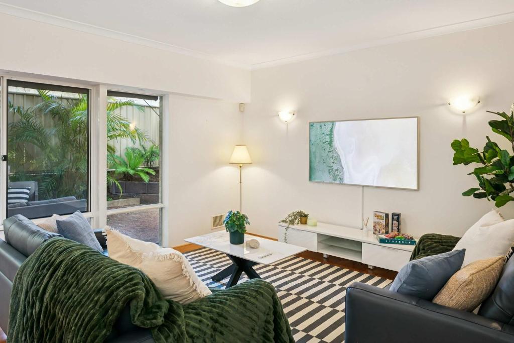 Kingsley Lake House 500Mbps Lakeside Wineries في بيرث: غرفة معيشة مع أريكتين وطاولة