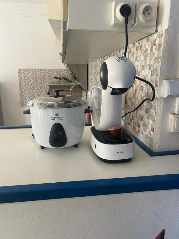 un mixeur blanc assis sur un comptoir à côté d'un mélangeur dans l'établissement Grand T2 Bwereny'S Lodge - Passamainty, à Mamoudzou