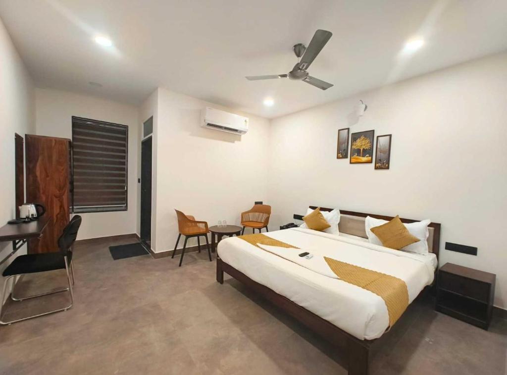 a bedroom with a bed and a table and chairs at Collection O Pragathi Nagar Nizamabad in Nizāmābād