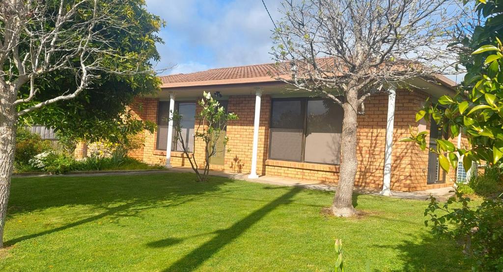 a brick house with a lawn in front of it at Percy's Cottage in Devonport