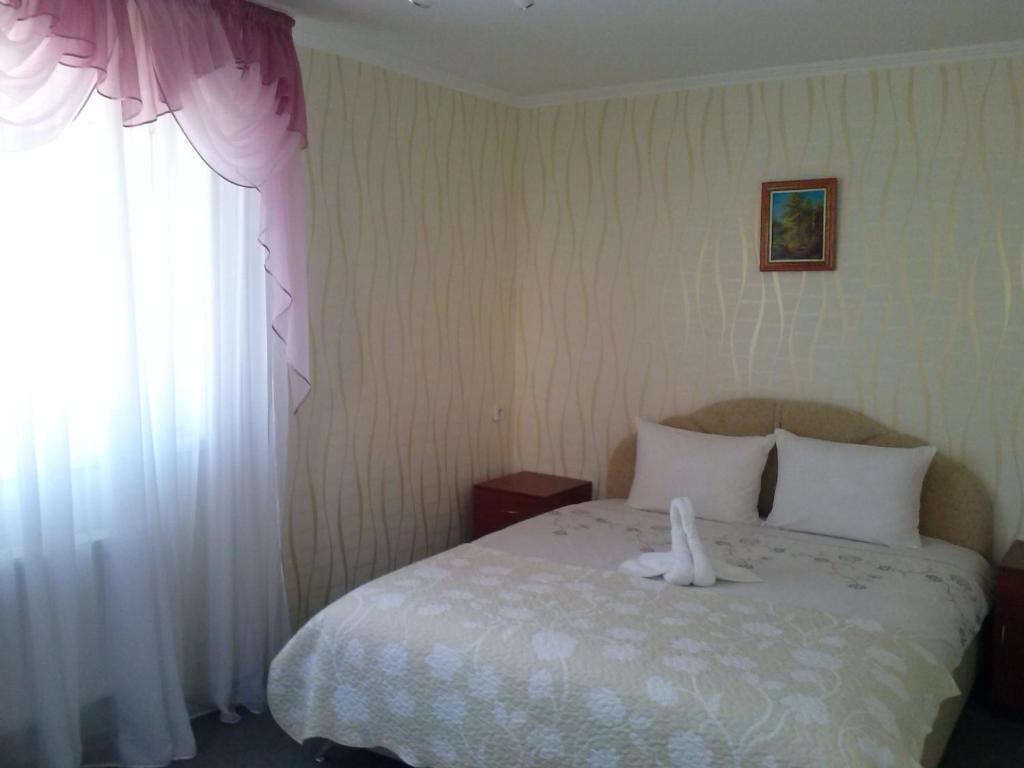 - une chambre avec un lit blanc et une fenêtre dans l'établissement Kak v gostinice, à Hadyach
