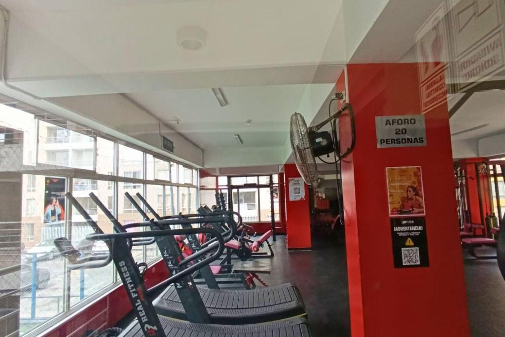 a gym with a row of treadmills at bonito departamento cerca al Aeropuerto Jorge Chávez in San Antonio