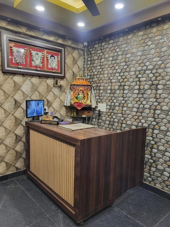a reception desk in a room with a wall of rocks at Hotel New Pratap in Haridwār