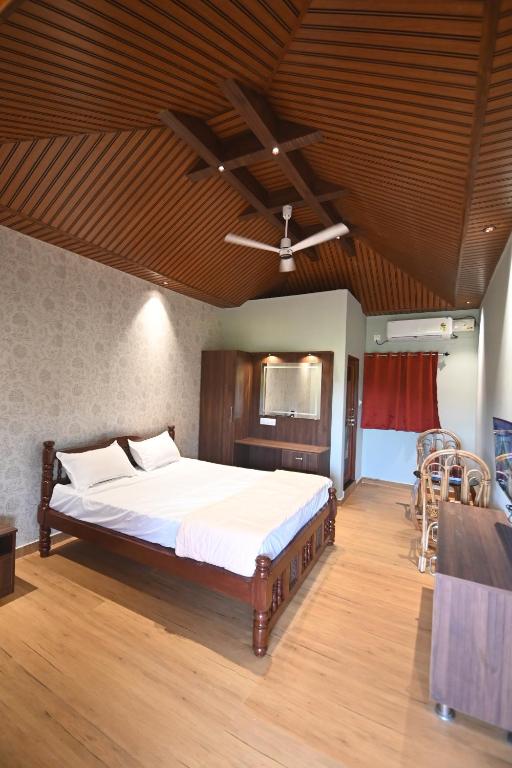 une chambre avec un lit et un ventilateur de plafond dans l'établissement Basilica Residency, à Māvalli