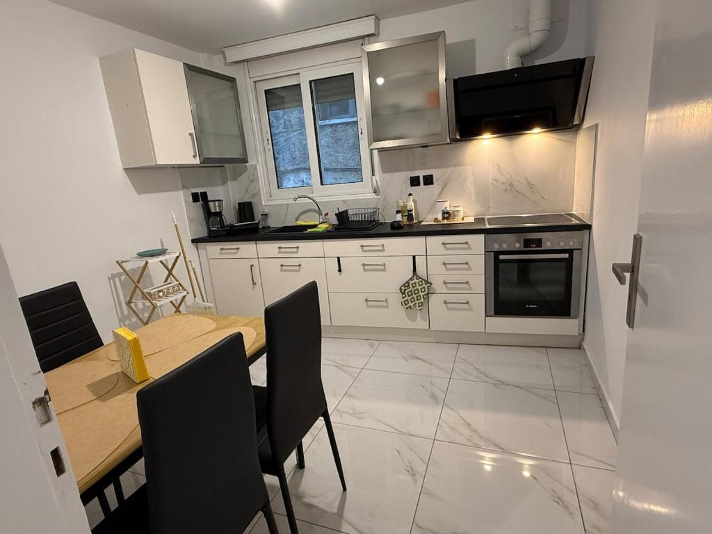 a kitchen with white cabinets and a table with chairs at CasaKallisti in Levádeia