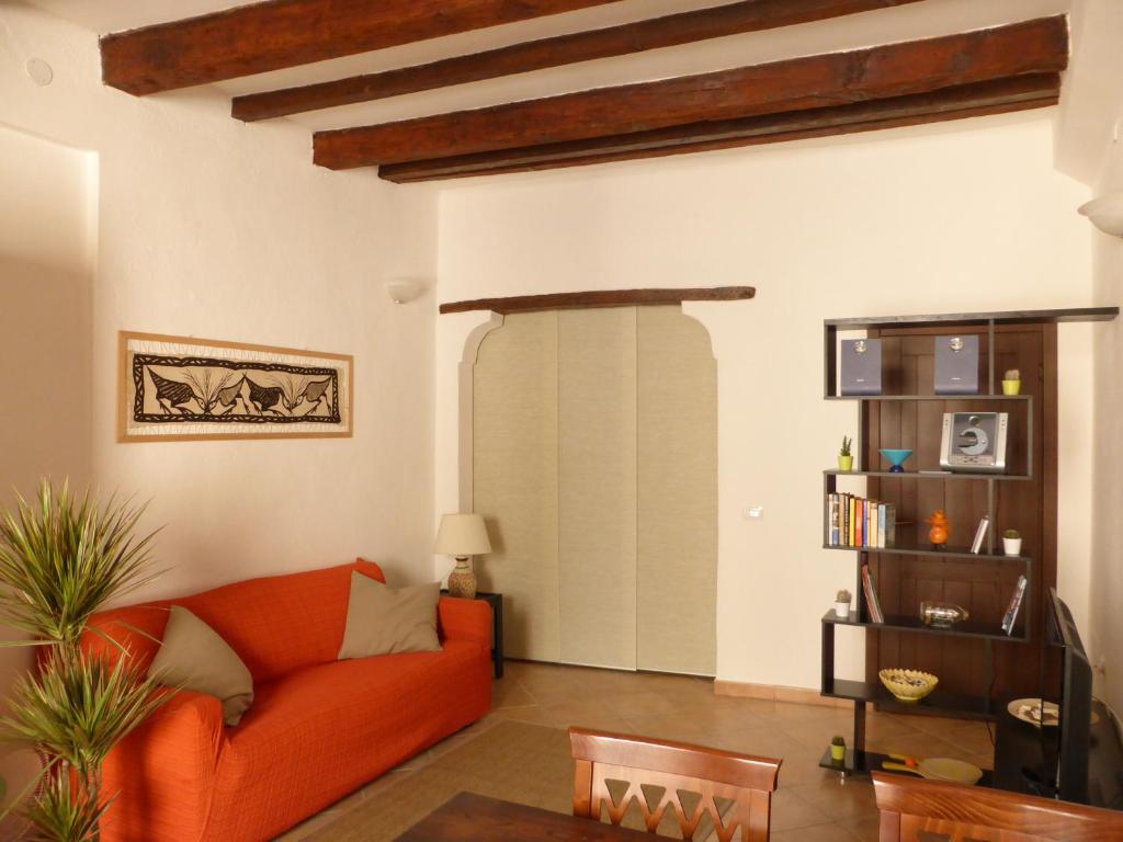 un soggiorno con divano arancione e libreria di Old Town Apartment ad Alghero