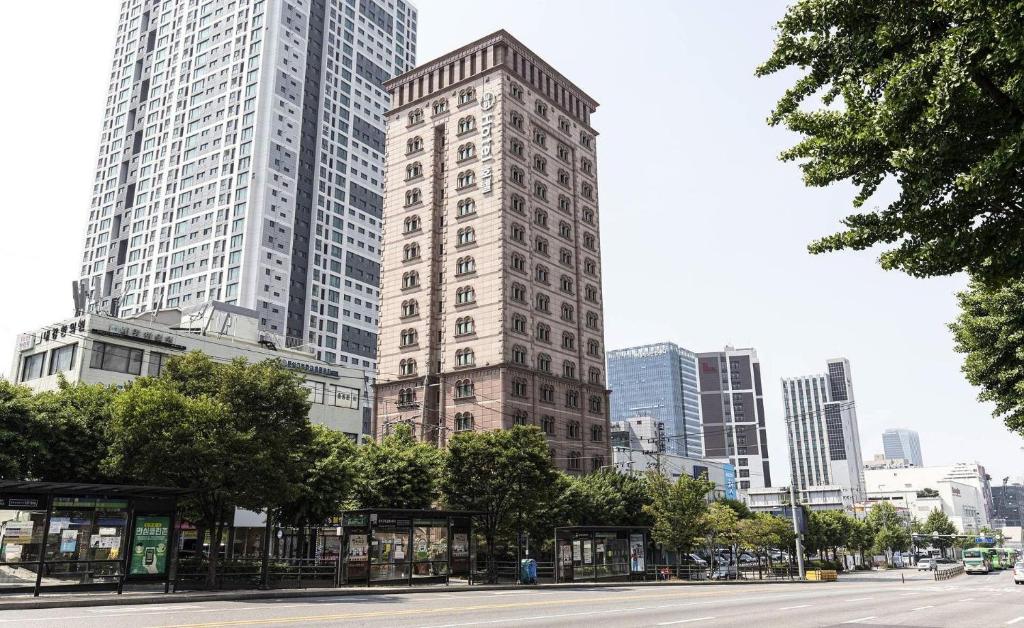 a tall building in a city with tall buildings at Doksan 3S Hotel in Seoul