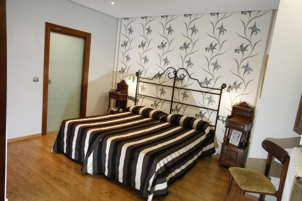 a bedroom with a bed with a black and white blanket at Hostal Rey Pedro I in Santo Domingo de la Calzada