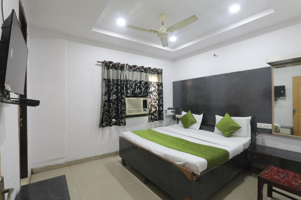 a bedroom with a large bed with green pillows at Dayals Hotel in Lucknow