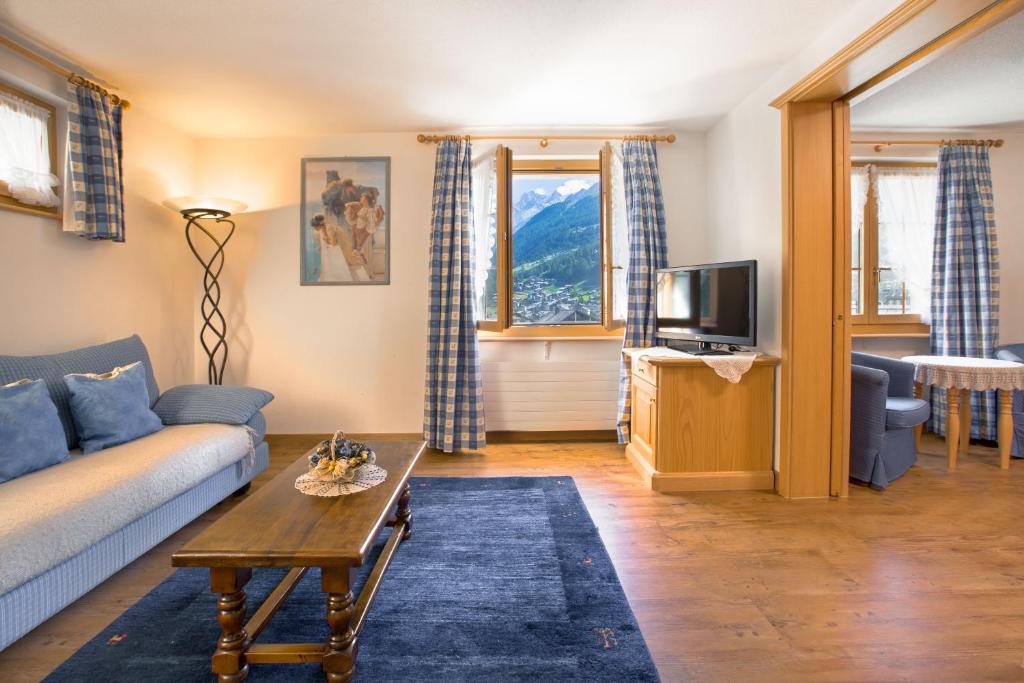 a living room with a couch and a table at Hotel Romantica in Zermatt