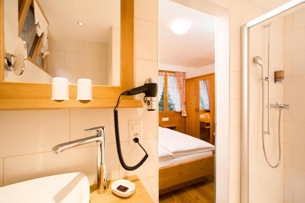 a bathroom with a shower and a phone on the wall at Hotel Romantica in Zermatt