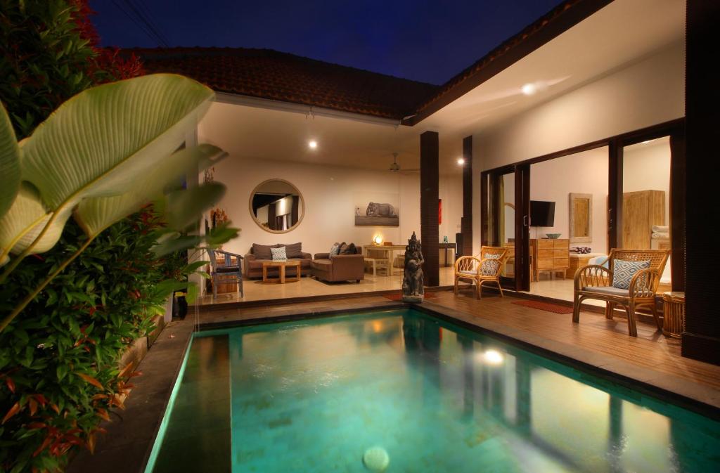 a villa with a swimming pool and a living room at Villa Lotus Flower Sanur in Sanur